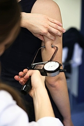 Ärztin misst das Körperfett am Arm