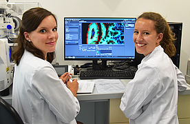 Zei Forscherinnen im Kittel vor Bildschirm